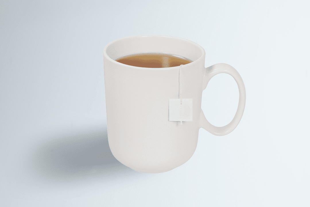 A white mug with a tea bag steeping in hot water.